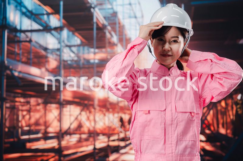 建設現場でヘルメットを被る女性