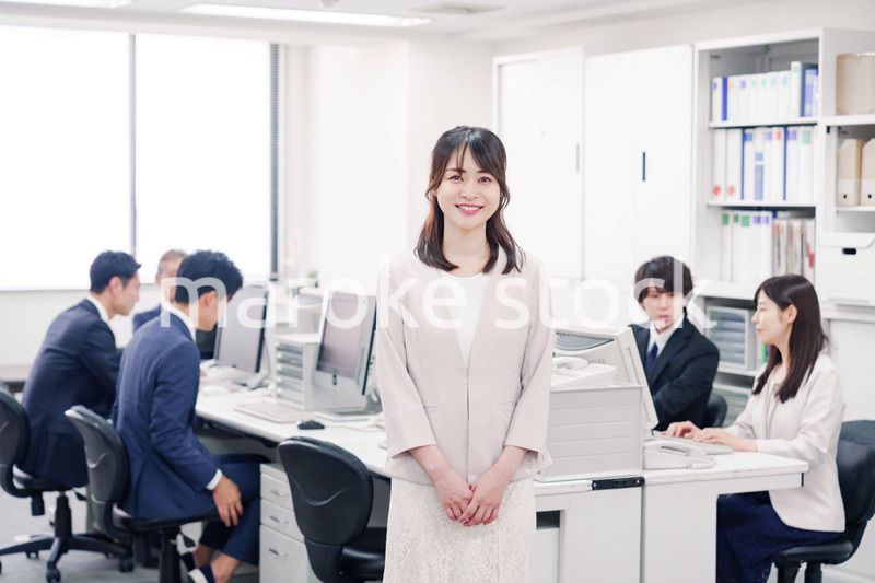 オフィスで笑顔を見せる若い女性社員