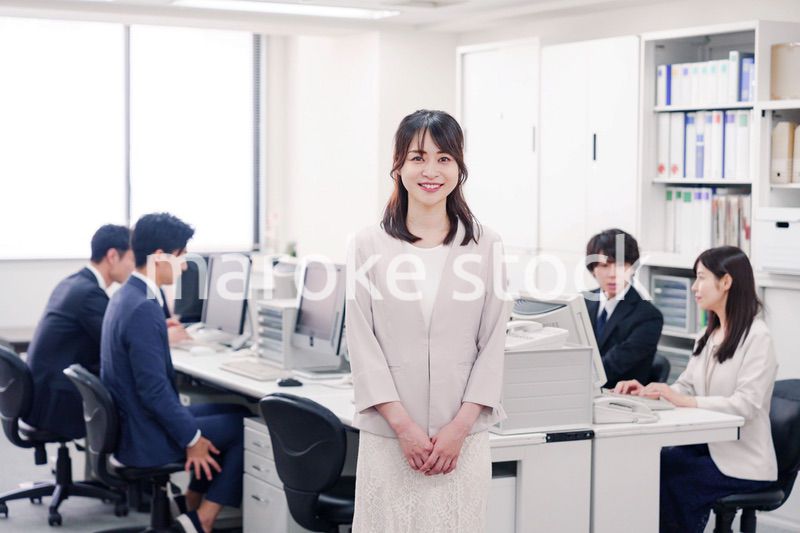 オフィスで笑顔を見せる若い女性社員