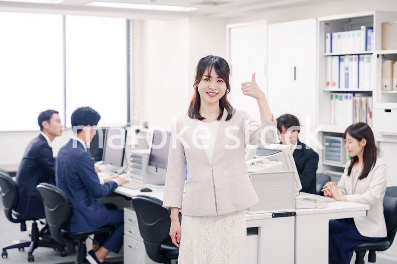 オフィスでOKサインをする若い女性社員