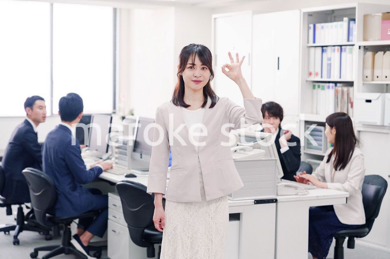 オフィスでOKサインをする若い女性社員