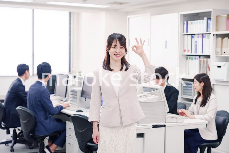 オフィスでOKサインをする若い女性社員