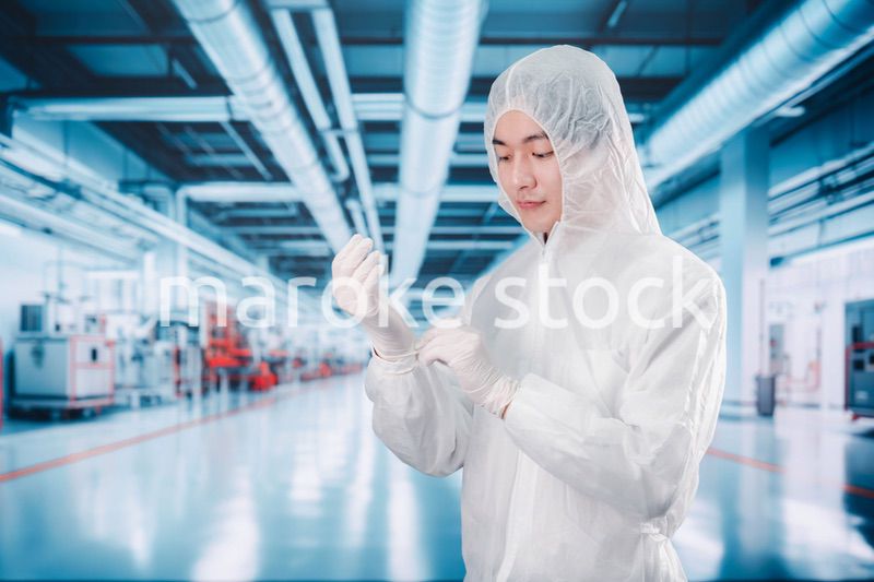 工場のクリーンルームに入る男性