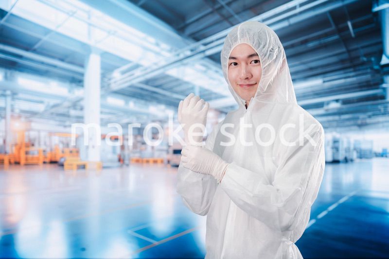 工場のクリーンルームに入る男性
