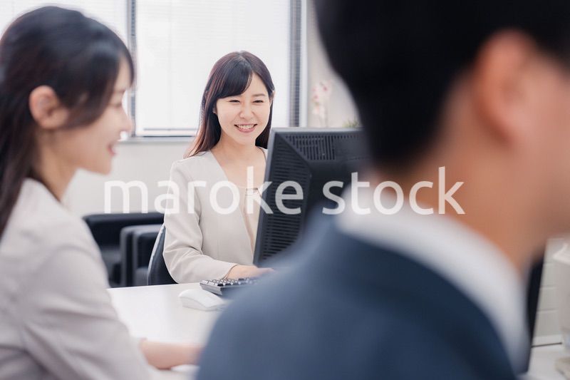 明るい雰囲気でデスクワークをするビジネスパーソン