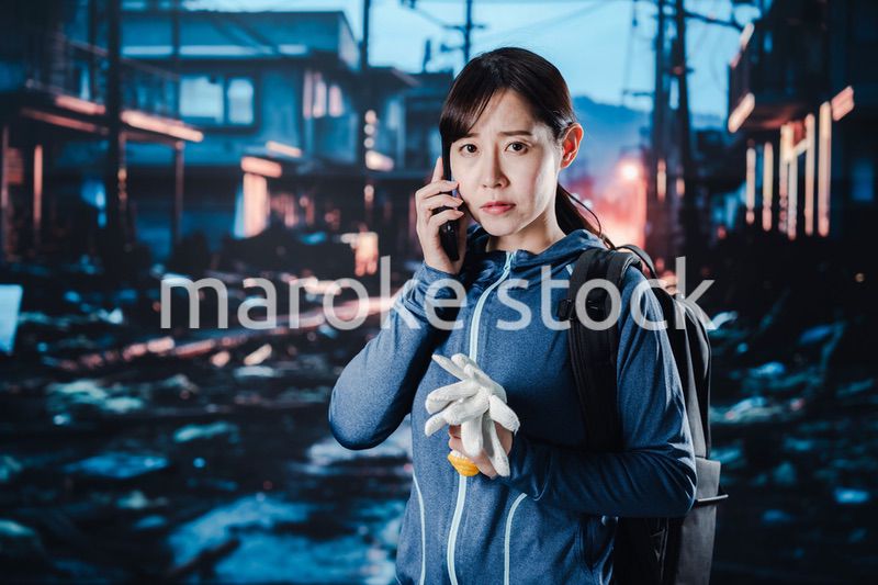 災害が発生し電話が繋がらずに困る女性