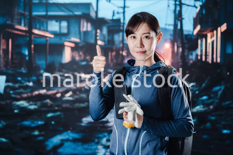 避難をしながらOKサインをする女性