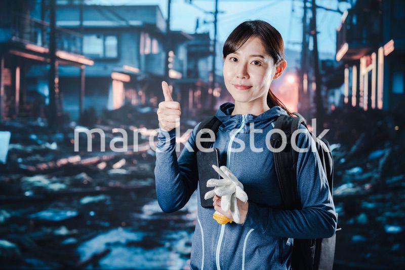 避難をしながらOKサインをする女性