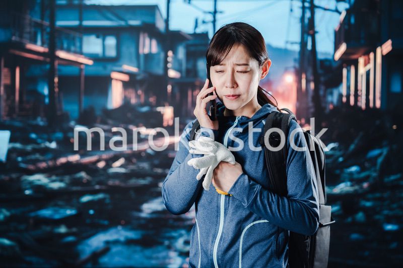 災害が発生し電話が繋がらずに困る女性