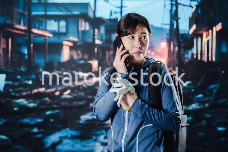 災害が発生し電話が繋がらずに困る女性