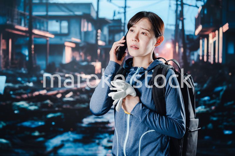 災害が発生し電話が繋がらずに困る女性