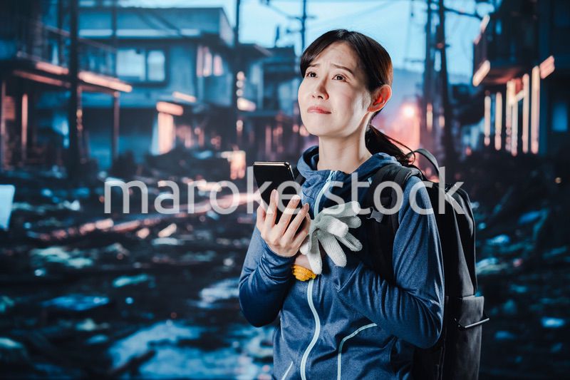 災害が発生し電話が繋がらずに困る女性