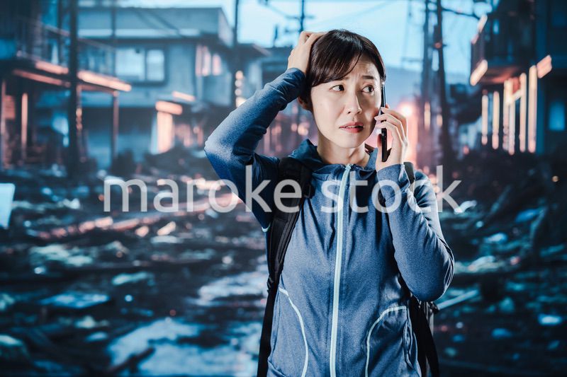 災害が発生し電話が繋がらずに困る女性