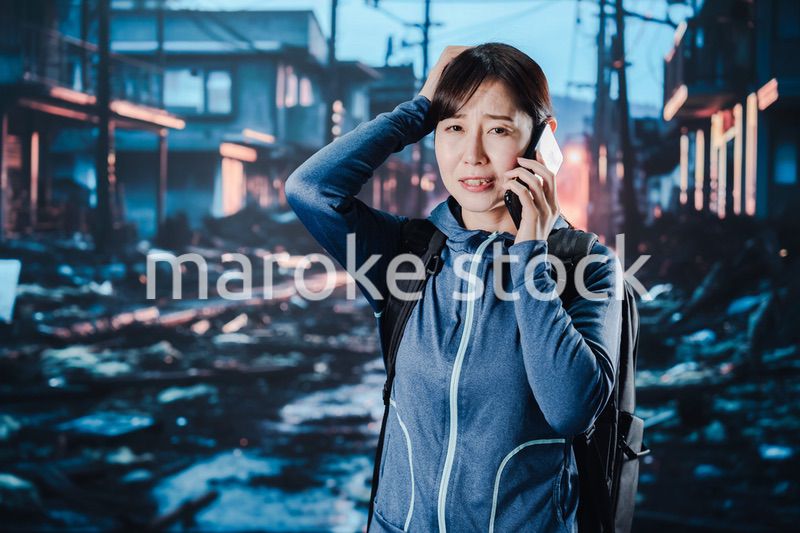 災害が発生し電話が繋がらずに困る女性