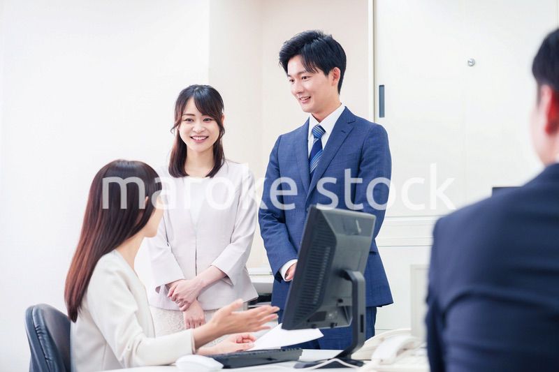 職場で上司に結婚の報告をするビジネスパーソンのカップル