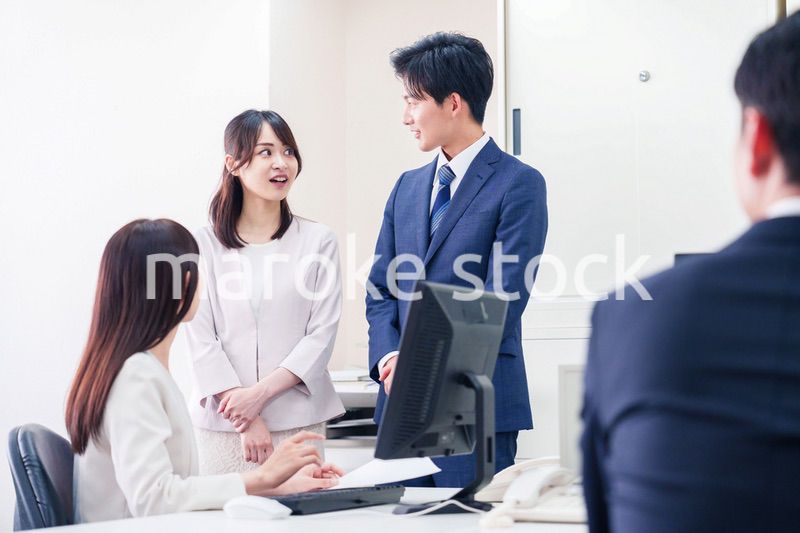 職場で上司に結婚の報告をするビジネスパーソンのカップル