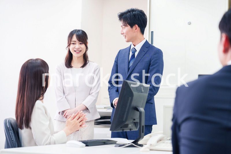 職場で上司に結婚の報告をするビジネスパーソンのカップル