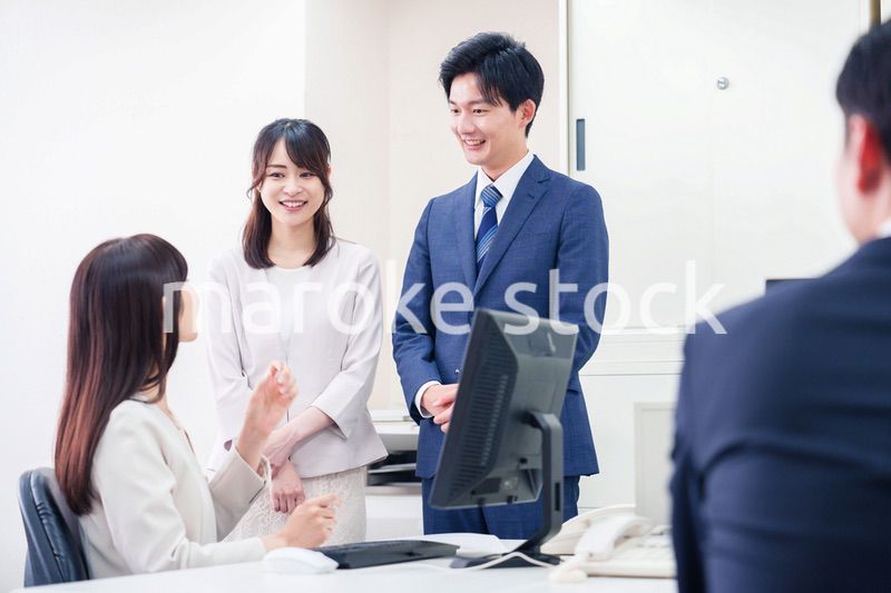 職場で上司に結婚の報告をするビジネスパーソンのカップル