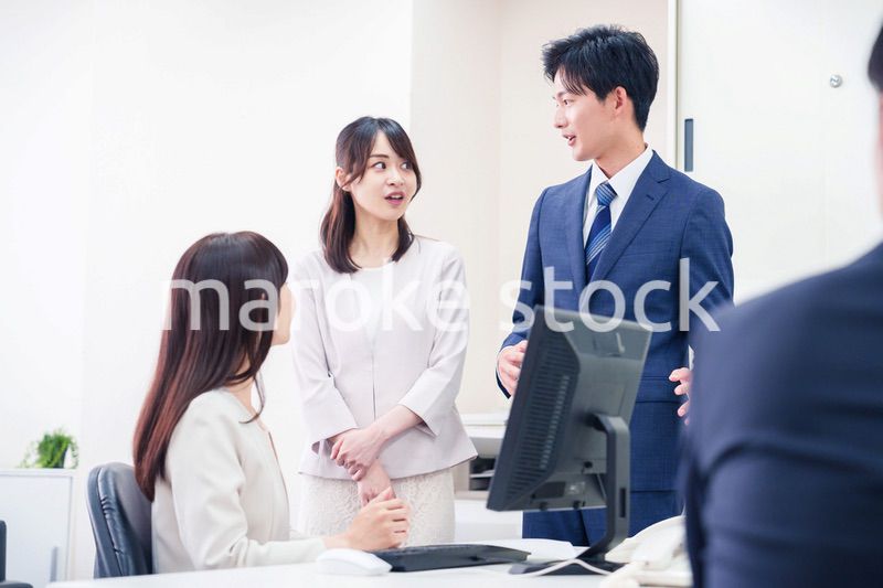 職場で上司に結婚の報告をするビジネスパーソンのカップル