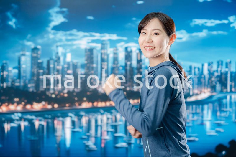 都会をランニングする若い女性