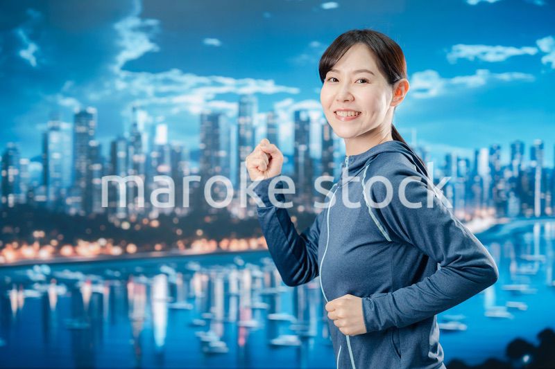 都会をランニングする若い女性