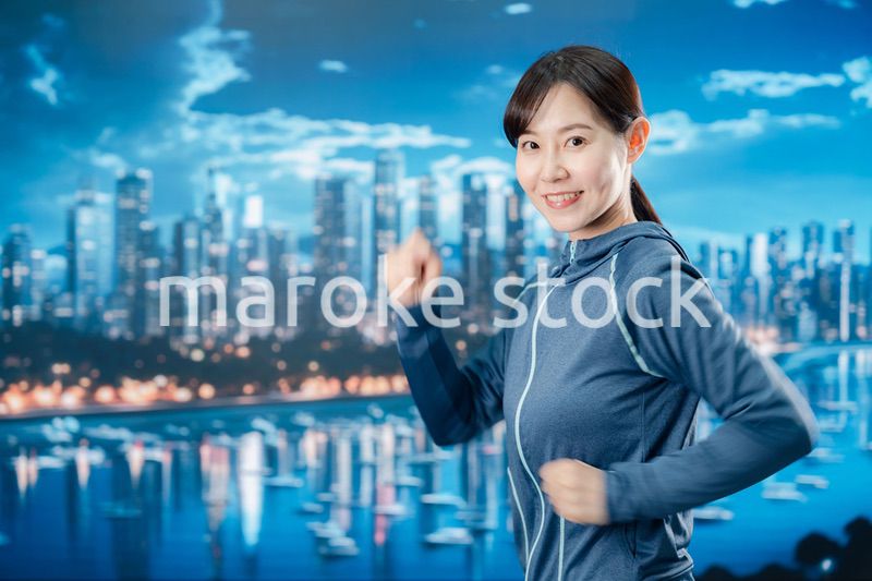 都会をランニングする若い女性