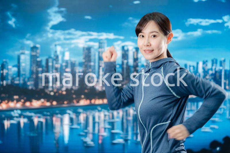 都会をランニングする若い女性