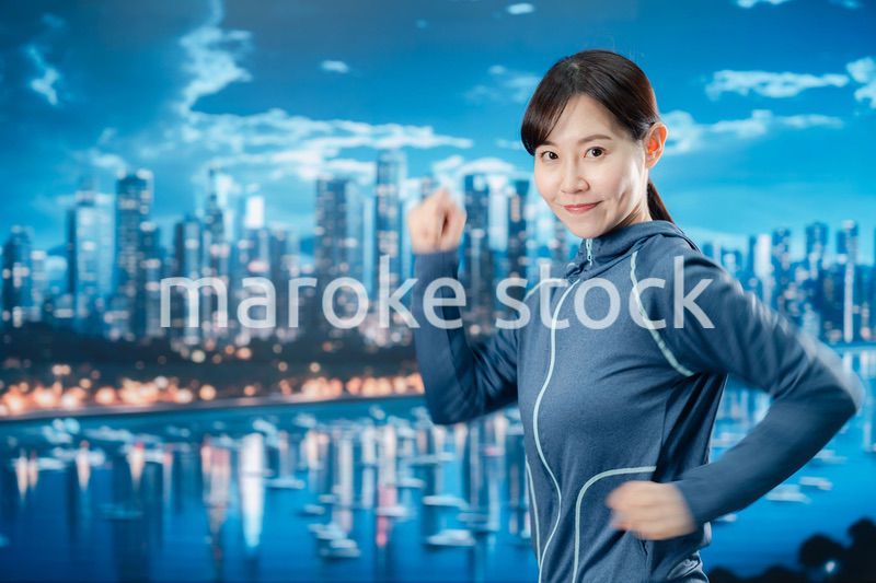 都会をランニングする若い女性