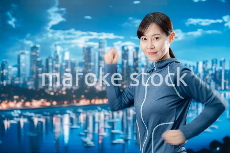 都会をランニングする若い女性