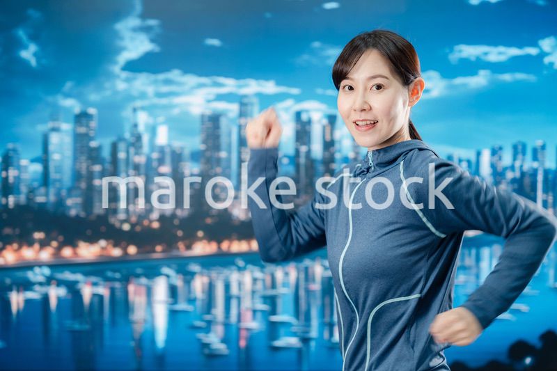 都会をランニングする若い女性