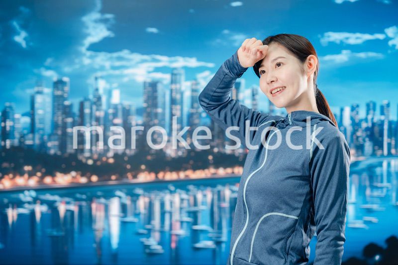 都会をランニングする若い女性