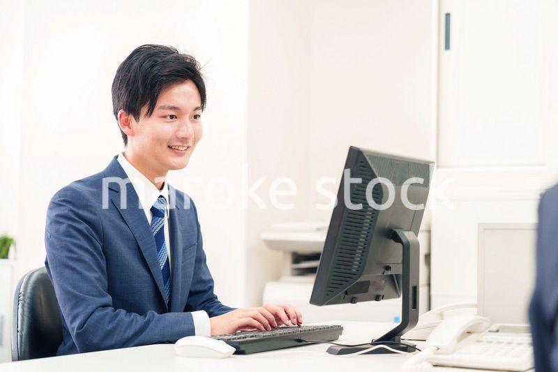 オフィスでデスクワークをする若い男性