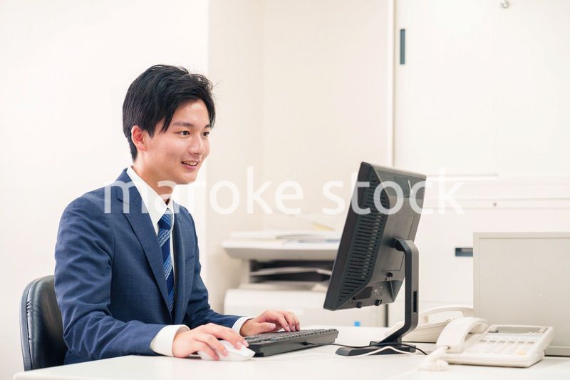 オフィスでデスクワークをする若い男性