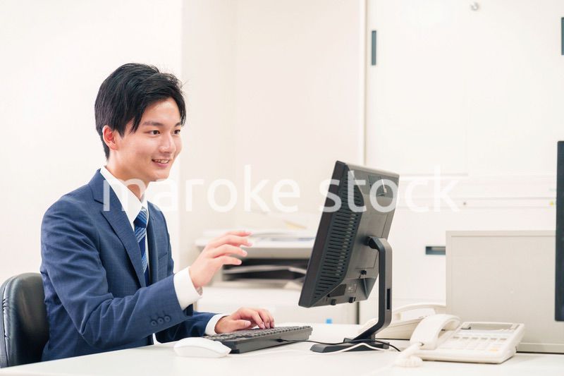 オフィスでデスクワークをする若い男性