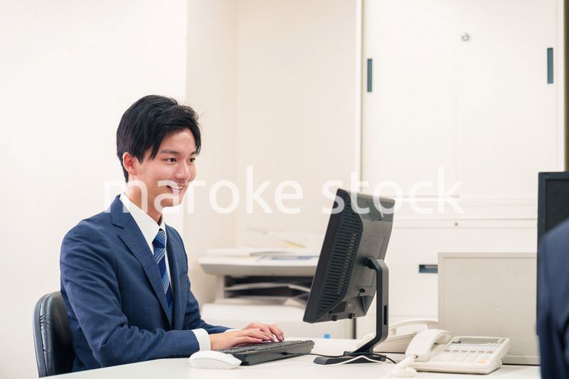オフィスでデスクワークをする若い男性
