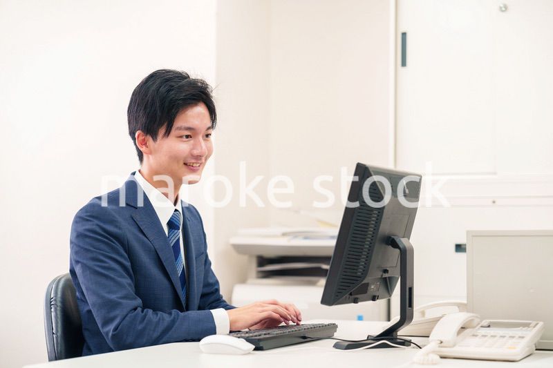 オフィスでデスクワークをする若い男性