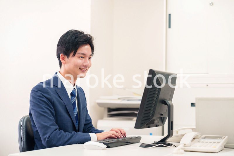オフィスでデスクワークをする若い男性