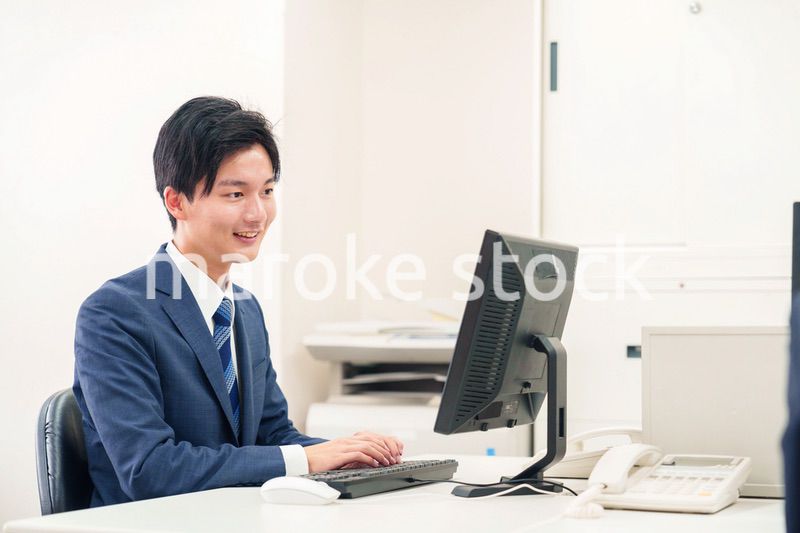 オフィスでデスクワークをする若い男性