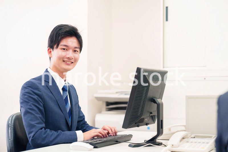 オフィスでデスクワークをする若い男性