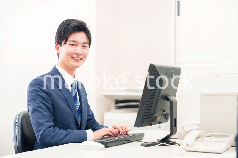 オフィスでデスクワークをする若い男性
