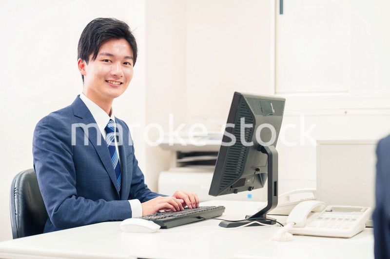 オフィスでデスクワークをする若い男性