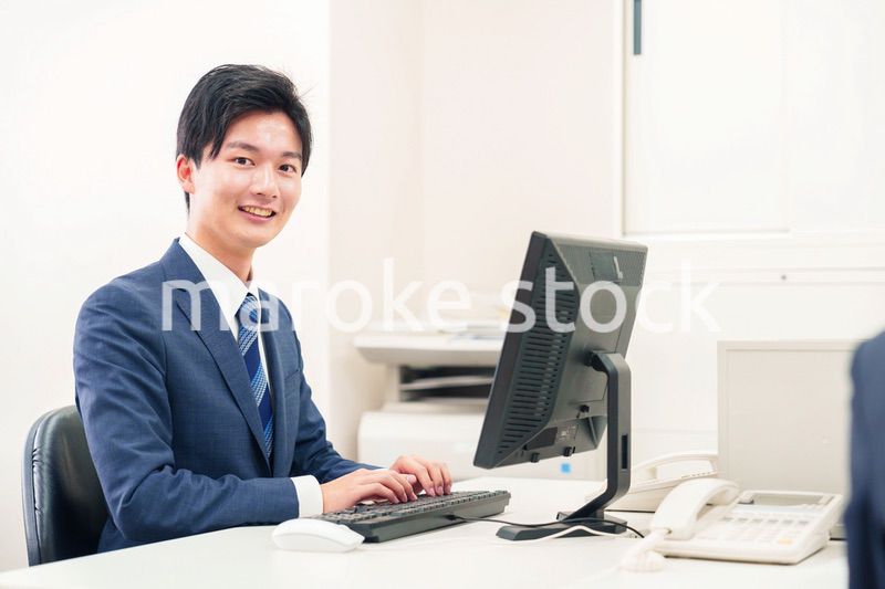 オフィスでデスクワークをする若い男性