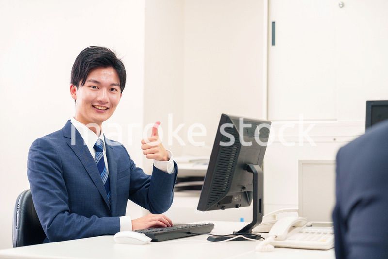 オフィスでデスクワークをする若い男性