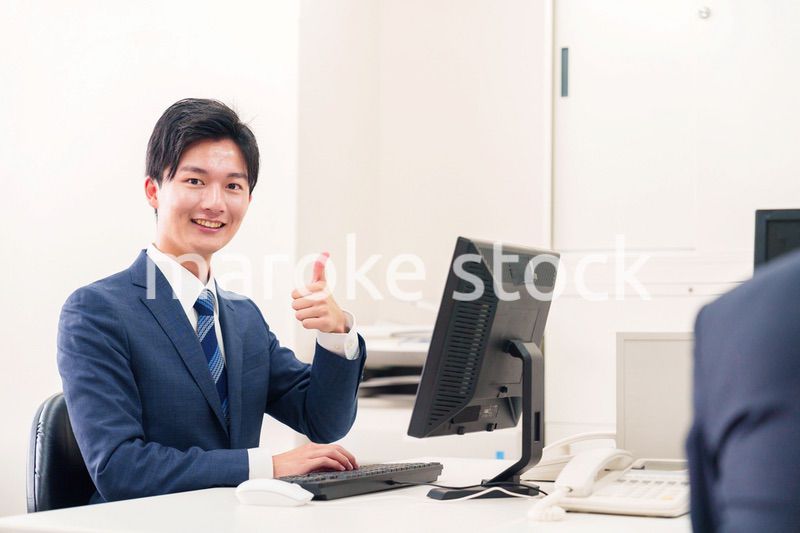 オフィスでデスクワークをする若い男性