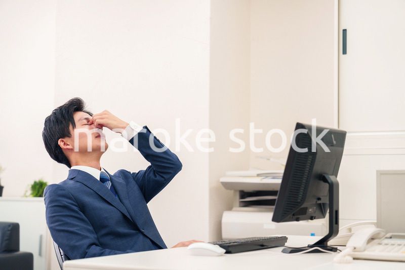 オフィスでドライアイに苦しむビジネスマン