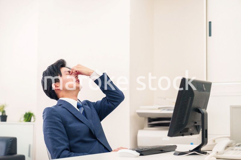 オフィスでドライアイに苦しむビジネスマン