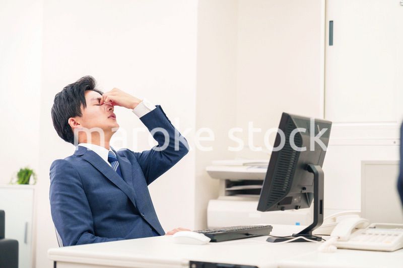 オフィスでドライアイに苦しむビジネスマン