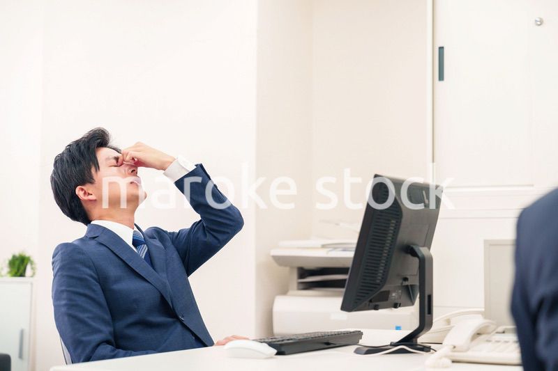 オフィスでドライアイに苦しむビジネスマン