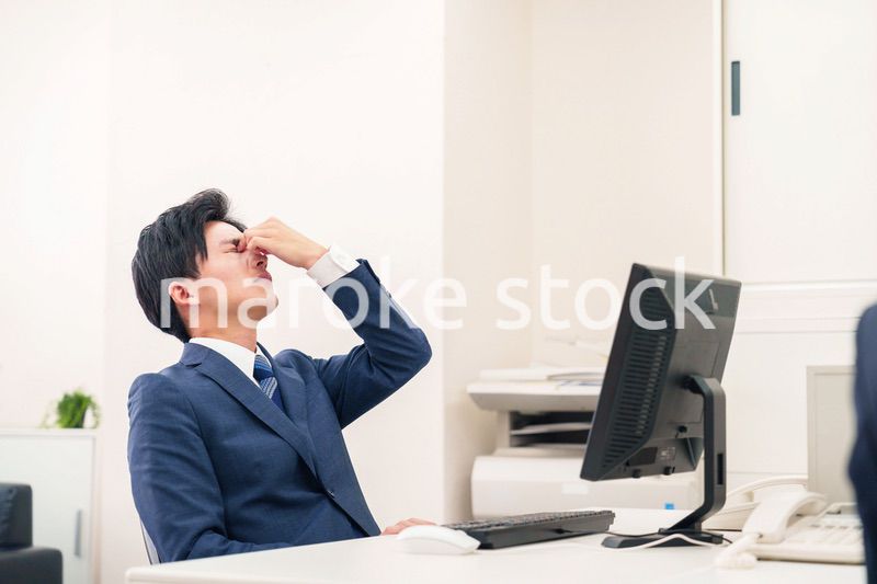 オフィスでドライアイに苦しむビジネスマン