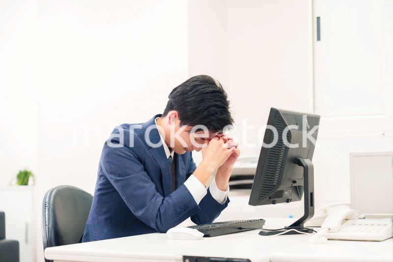 オフィスでドライアイに苦しむビジネスマン